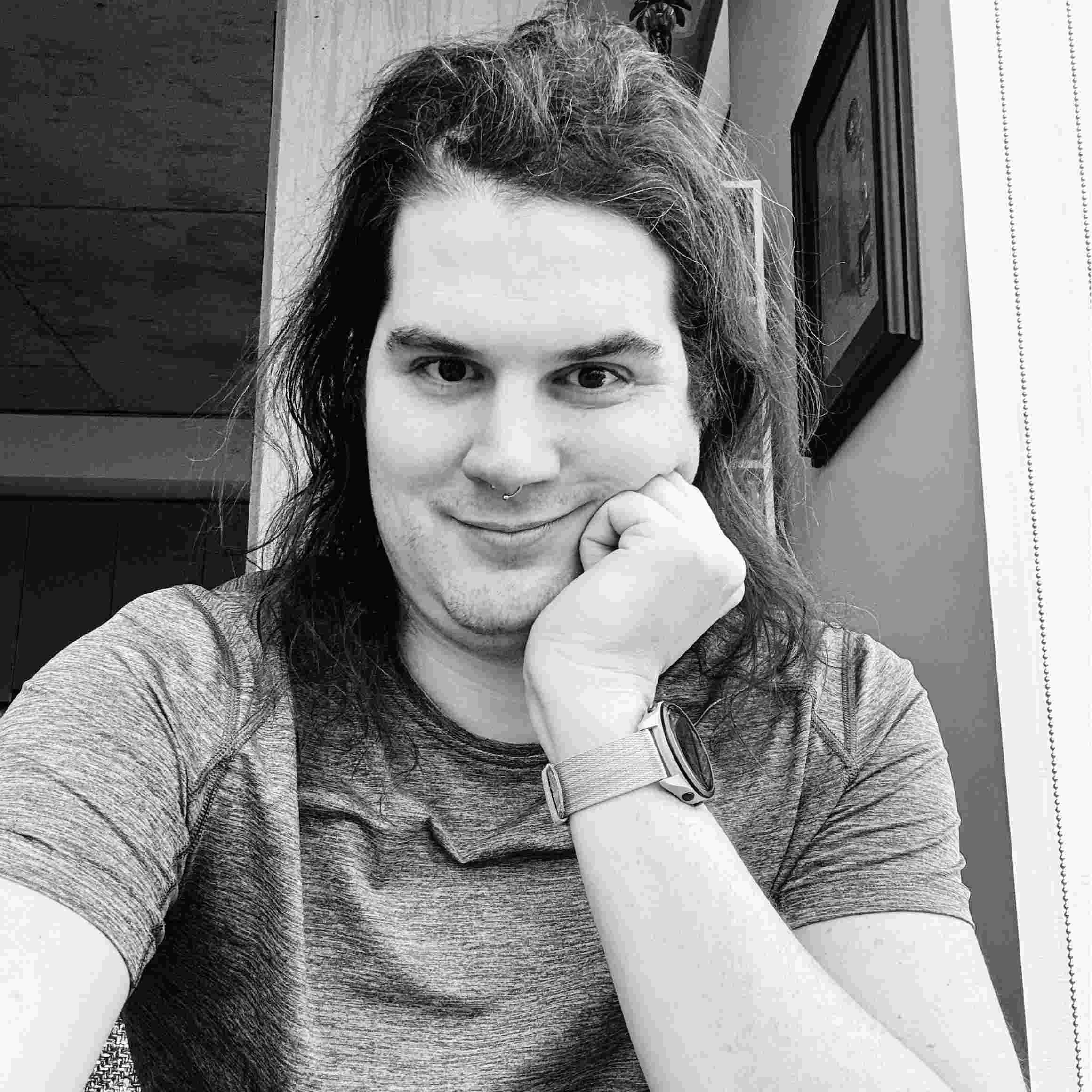 Image of Matt Farah - a white appearing mid-30's masculine person with long brown hair and brown eyes. 